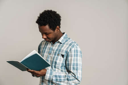 Black unshaven man in plaid shirt posing with exercise book isolated over white backgroundの写真素材