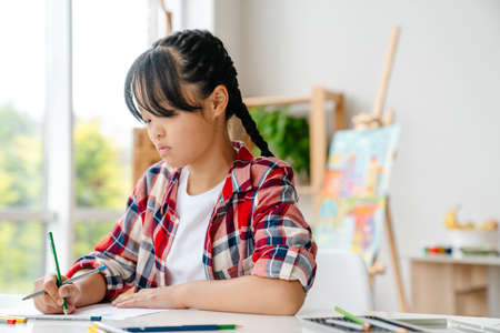 Asian girl drawing during class in art school indoorsの写真素材