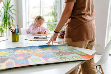 Mature teacher talking with her pupils during class in art school indoors
