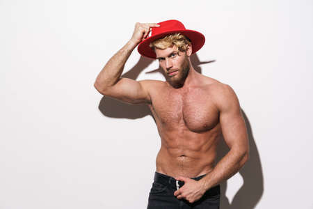 Shirtless blonde man wearing red hat posing on camera isolated over white backgroundの写真素材