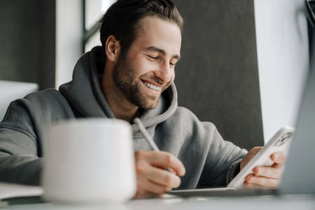 Young beard man using mobile phone while working in office