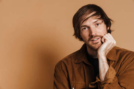 White unshaven man in shirt posing and looking at camera isolated over beige backgroundの写真素材