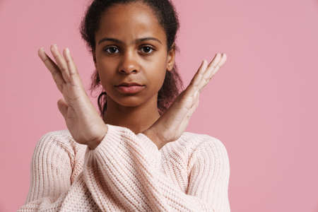 Brunette black girl showing stop gesture at camera isolated over pink backgroundの写真素材