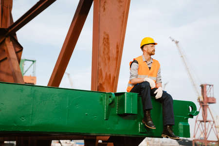 White ginger man wearing helmet and vest working in portの写真素材