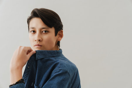 Asian boy wearing shirt posing and looking at camera isolated over white background