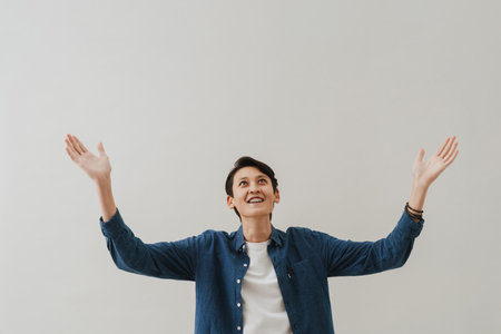 Asian boy with dental braces smiling and gesturing isolated over white backgroundの写真素材