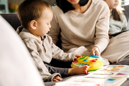 Asian boy playing while spending time with her mother at home