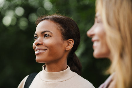 Multiracial women talking and smiling after yoga practice in summer parkの写真素材