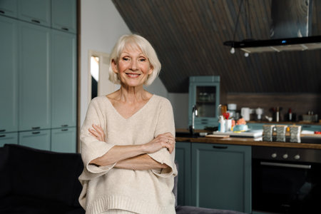 White senior woman smiling and looking at camera at homeの写真素材