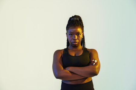 Black young sportswoman posing with arms crossed isolated over white backgroundの写真素材