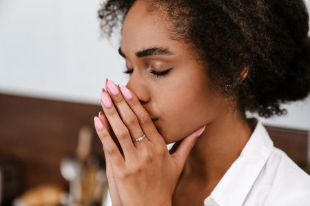 Young black woman being upset and thinking about abortion at homeの写真素材
