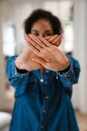 Young black woman gesturing stop sign with hands and protesting against abortionの写真素材