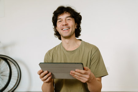 White man laughing and using tablet while spending time at homeの写真素材