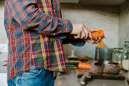 White man wearing shirt cutting vegetables while cooking lunch in kitchen at home