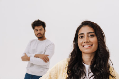 Young indian couple looking at camera while posing together isolated over white backgroundの写真素材