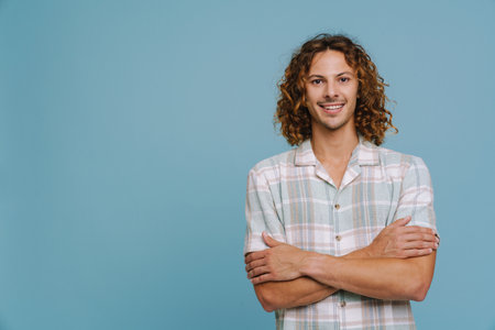 Ginger european man wearing shirt smiling and looking at camera isolated over blue backgroundの写真素材