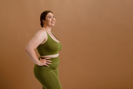 White young woman smiling and posing while standing isolated over beige backgroundの写真素材
