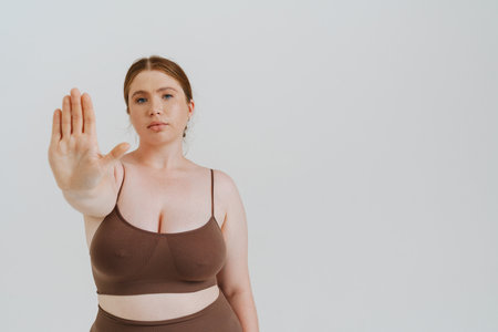 European woman with ginger hair showing stop gesture isolated over white backgroundの写真素材