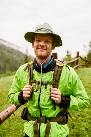 Young white man wearing trekking equipment hiking in mountain forestの写真素材
