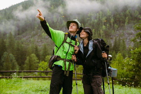 Young white people wearing trekking equipment hiking in mountain forestの写真素材