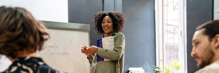 Middle aged african female teacher explaning new topic to students in class