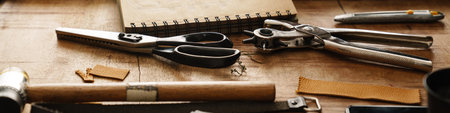 White craftsman working with leather at wooden table in workshop