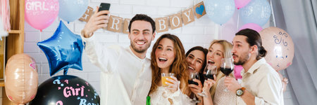 Happy young friends taking selfie photo together during gender reveal party indoorsの写真素材