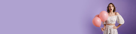 Shocked young woman exclaiming while posing with balloons isolated over purple wall