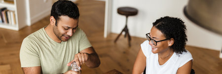 Middle eastern man and woman smiling while having breakfast in kitchen at homeの写真素材