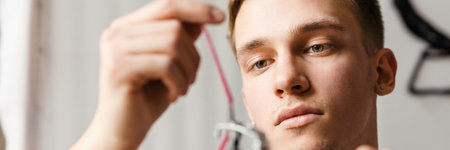 Young white man working with sewing machine indoorsの写真素材