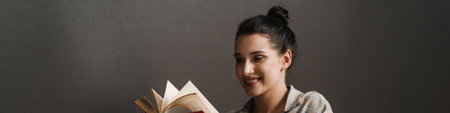 Smiling mid aged white casual brunette woman reading diary while sitting at the office desk