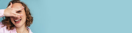 Young ginger woman with wavy hair gesturing and looking at camera isolated over blue background