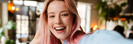Young beautiful woman with pink hair smiling and taking selfie photo in cafe