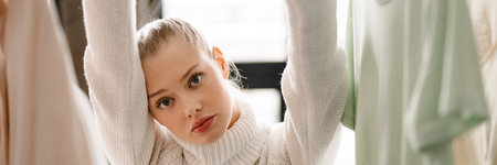 Young blonde white woman choosing clothes at homeの写真素材