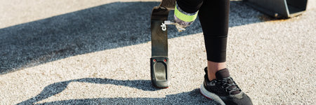 Young sportswoman with prosthesis standing on city bridgeの写真素材