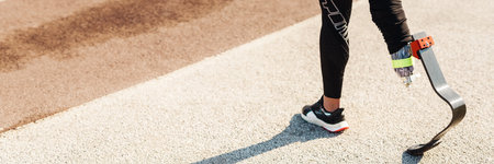 Young sportswoman with prosthesis walking on city streetの写真素材