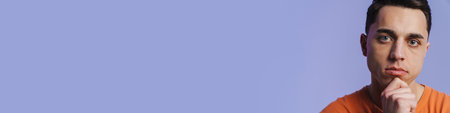 Young brunette man posing and looking at camera isolated over purple background