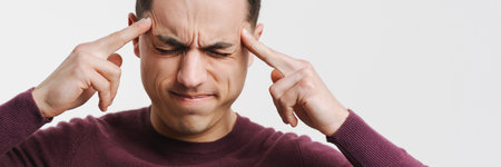 Young brunette man with headache rubbing his temples isolated over white background