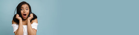 Young black woman with pigtails expressing surprise at camera isolated over blue background