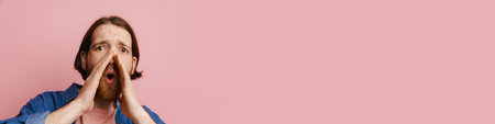 Young ginger man with beard gesturing and screaming at camera isolated over pink background