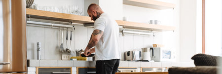 White man with prosthesis cooking lunch in kitchen at homeの写真素材