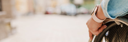 Cropped photo of woman sitting in wheelchair on city streetの写真素材