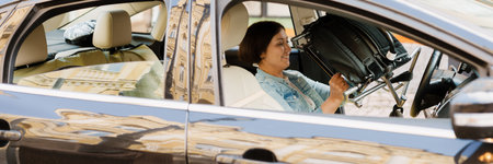 Brunette woman holding wheelchair while sitting in car on city street