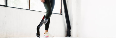 Young woman with prosthesis standing while working out indoorsの写真素材