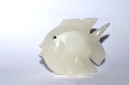 White - cream ceramic fish figurine on gray backgroundの写真素材