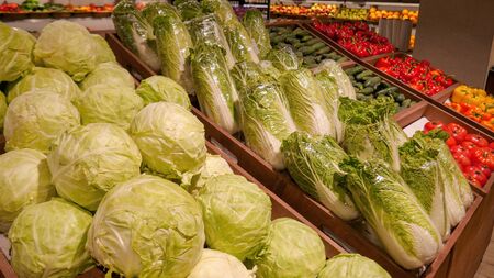 Cabbage, Beijing cabbage, tomatoes, peppers and other vegetables are in the drawer on the shop windowの写真素材