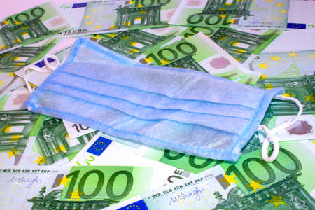 Medical protective surgical mask lies on money 100 euro banknotes.の写真素材