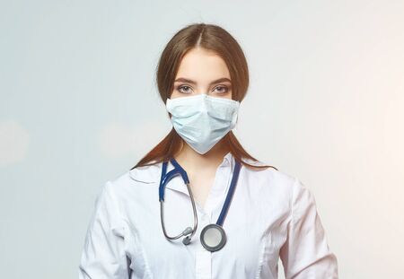 Covid19, coronavirus, a concept of healthcare and doctors. Portrait of a female doctor wearing a medical mask to prevent infection with the virusの写真素材