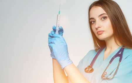 a female doctor holds a syringe in her handの写真素材