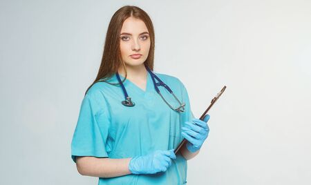 portrait of a doctor with clipboard and stethoscope isolated on a white backgroundの写真素材